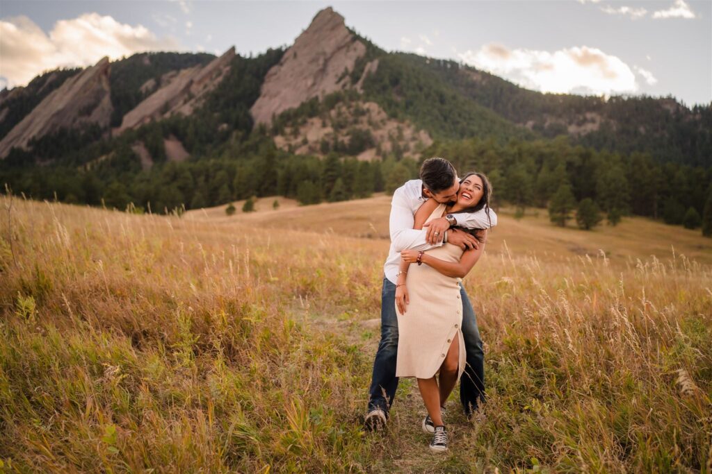 Engaged couple walking through Chautauqua Park during golden hour in Boulder.