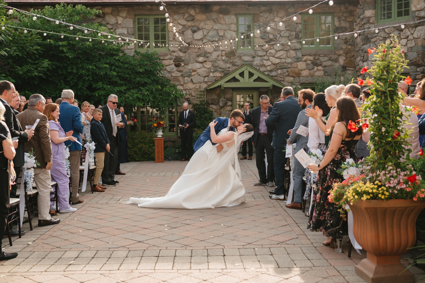 Groom dipping his bride for a kiss after their wedding ceremony