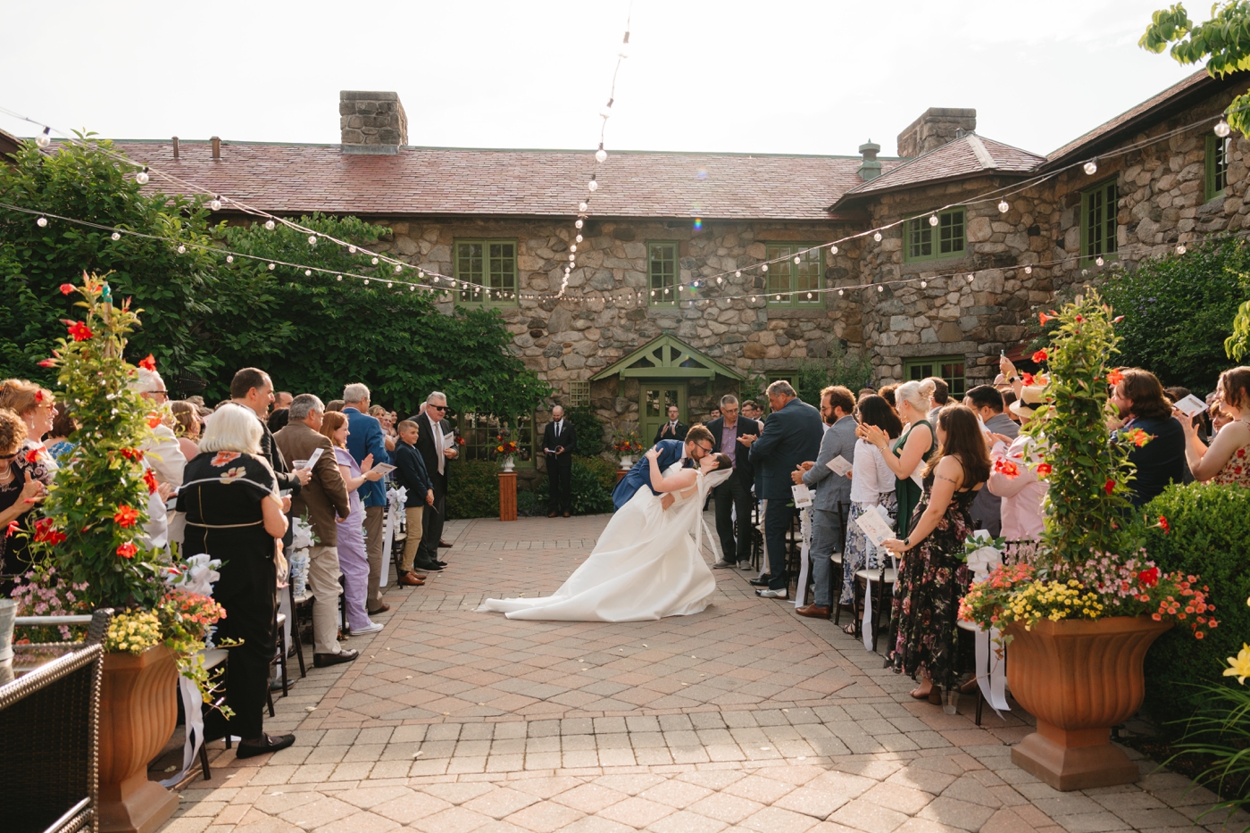 Groom dipping bride for a kiss after wedding ceremony