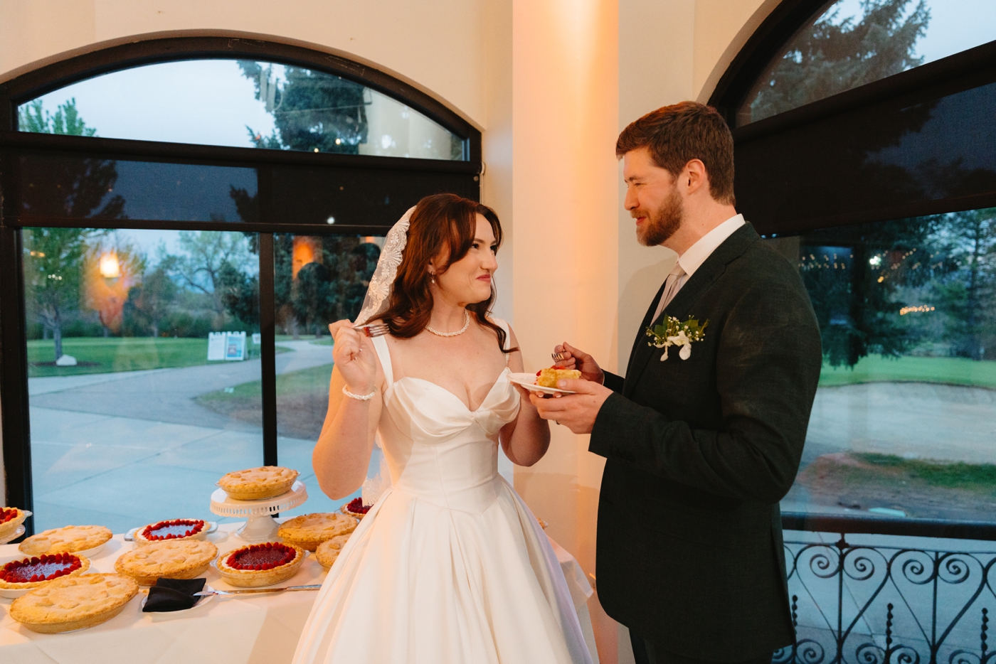 Bride and groom eating pie at their wedding reception