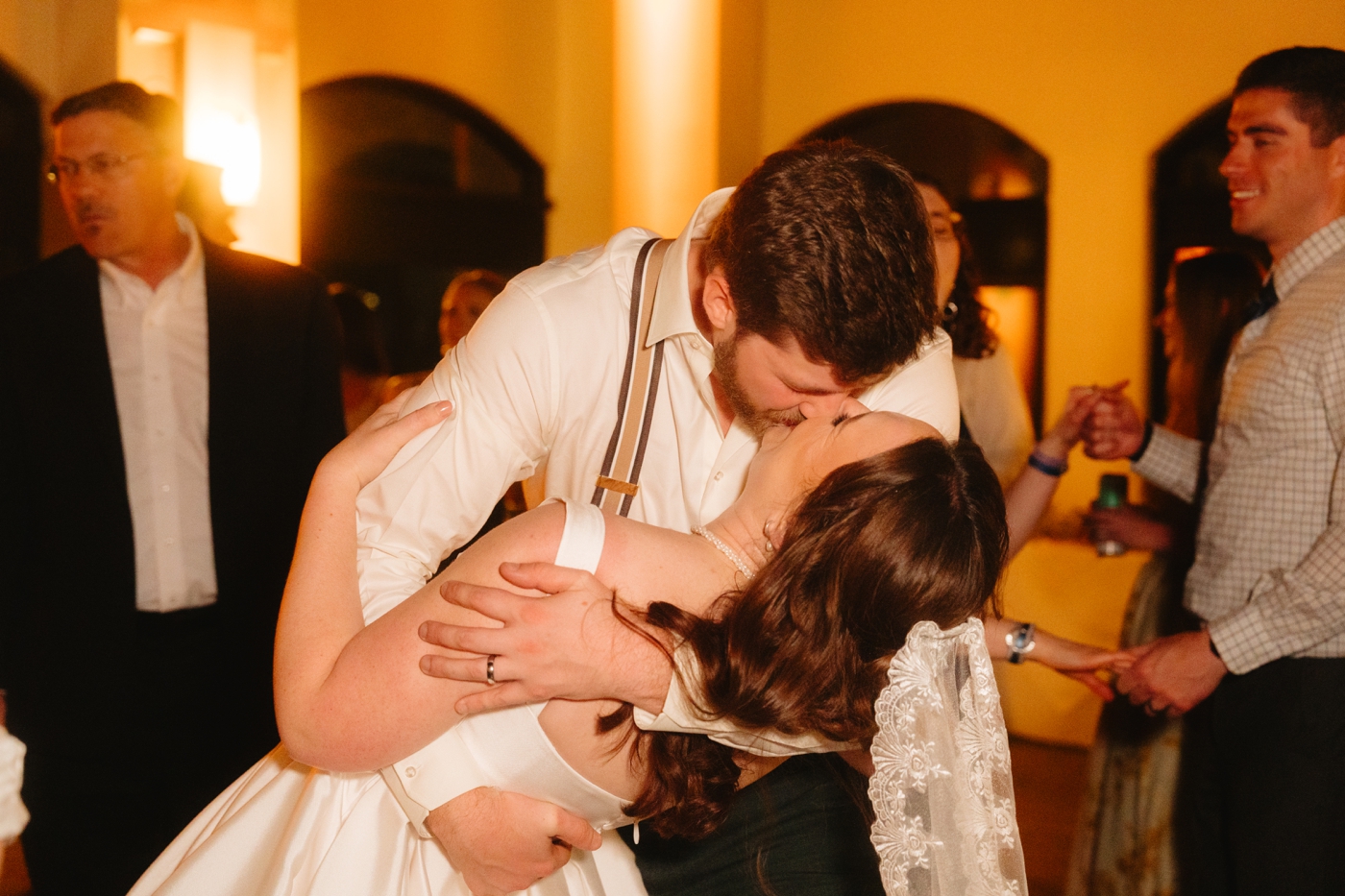 Groom kissing bride on the dance floor at their wedding reception