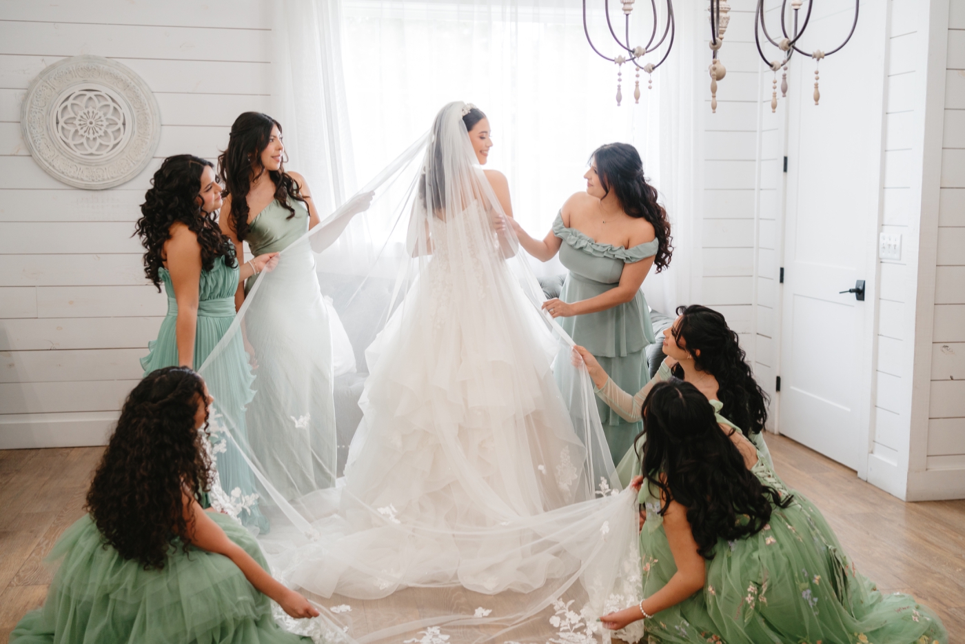 Bridesmaids helping bride with her veil